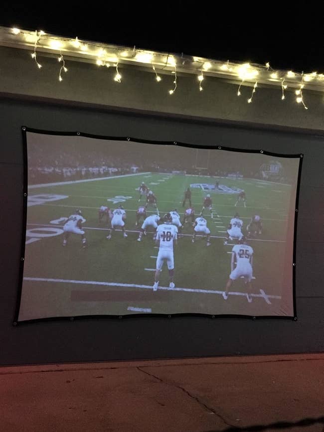 a screen with a football game projected onto it