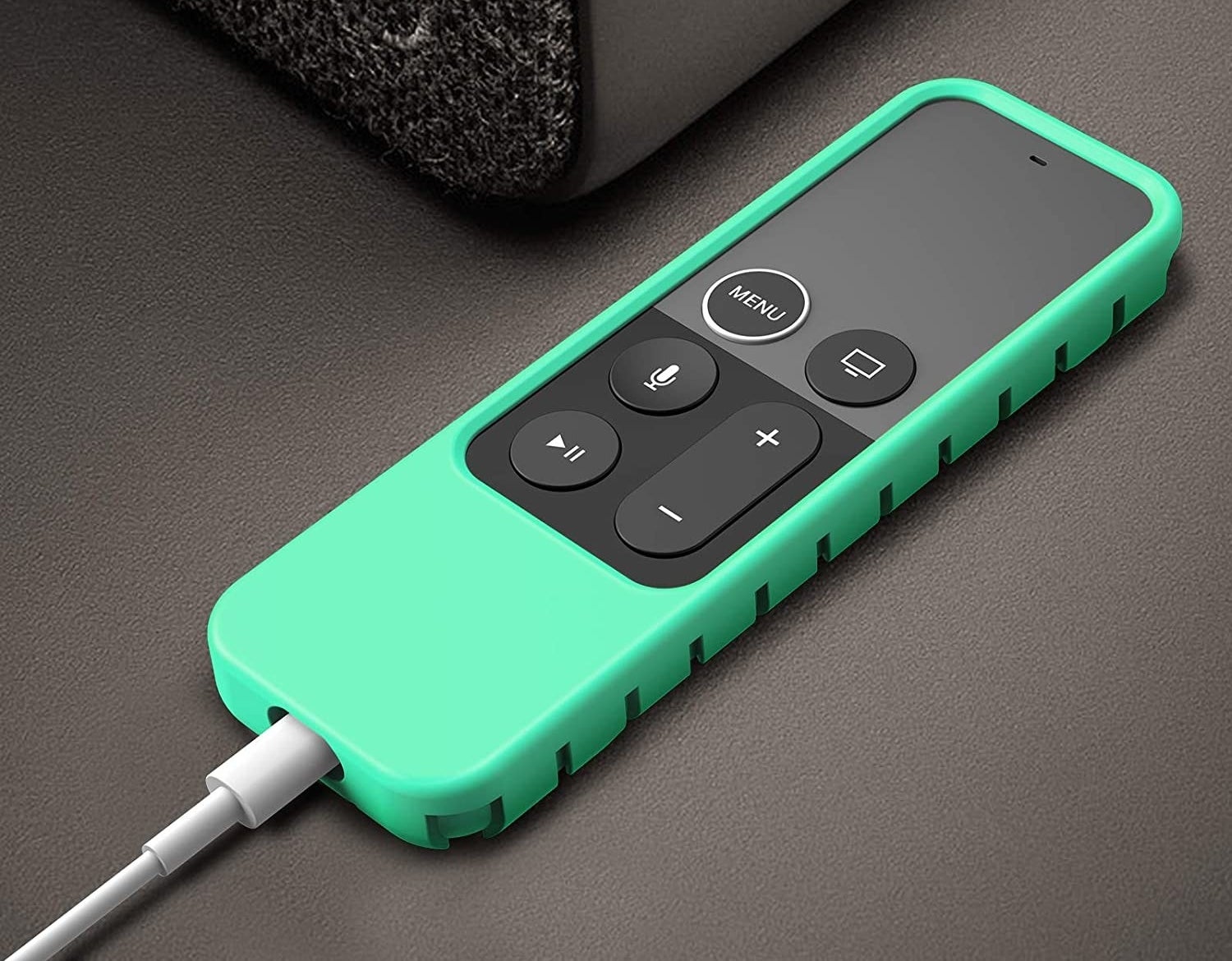 An Apple remote covered by a green silicone casing 