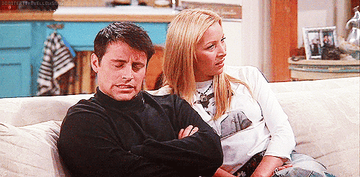 GIF of Joey from Friends sitting with Phoebe on the couch shaking his head saying no
