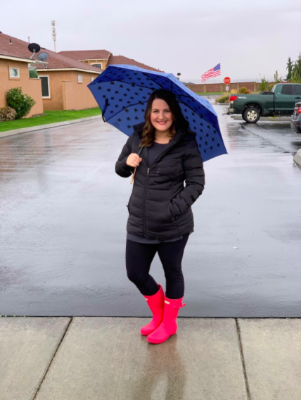 a reviewer wearing the boots in pink in the rain