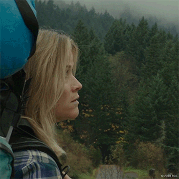 Woman with backpack stares out over the landscape
