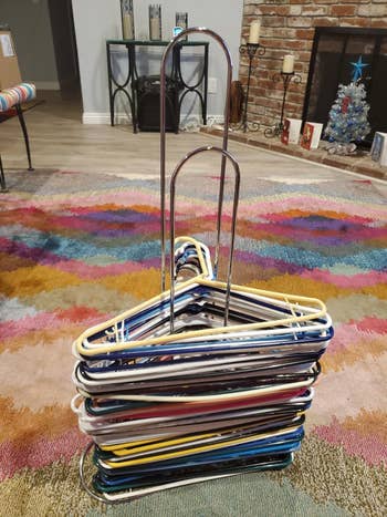 a reviewer photo of the hangers stacked neatly on the rack 