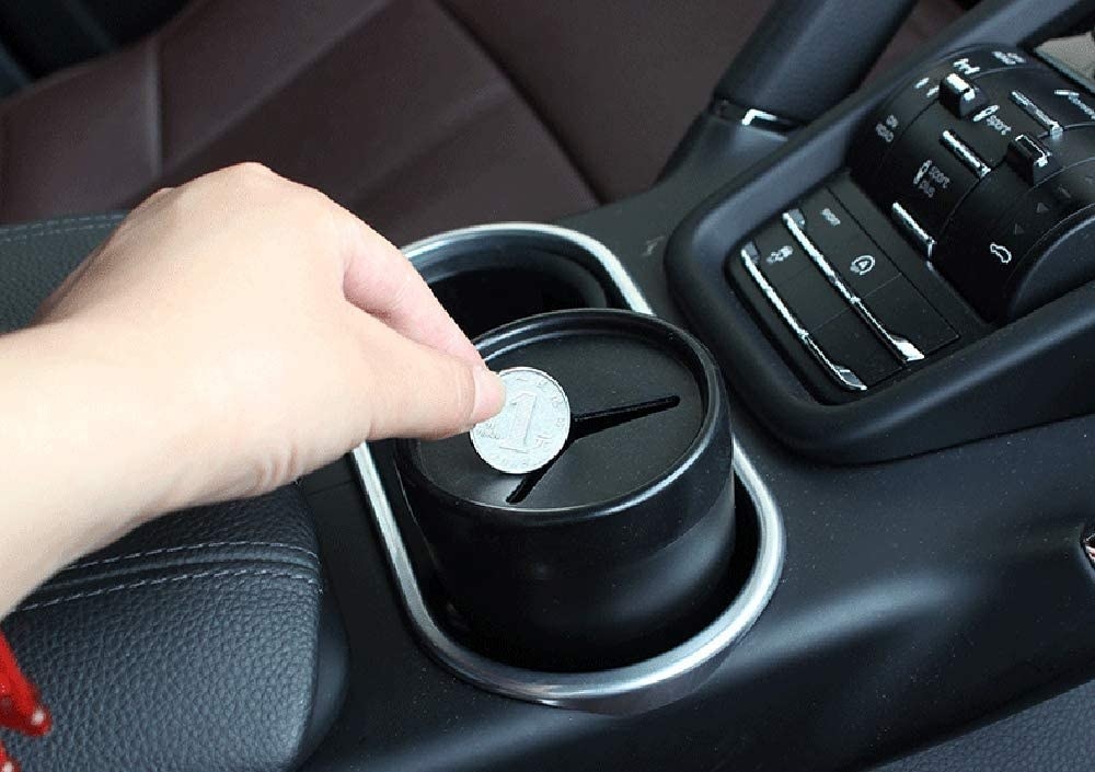 A person putting a coin into the holder