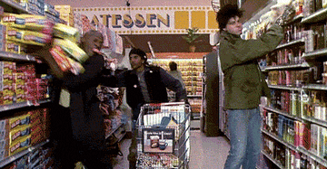 Three shoppers furiously throwing groceries in their cart