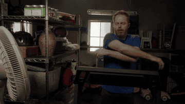 Jesse Tyler Ferguson from Modern Family working out and knocking over items on the shelf