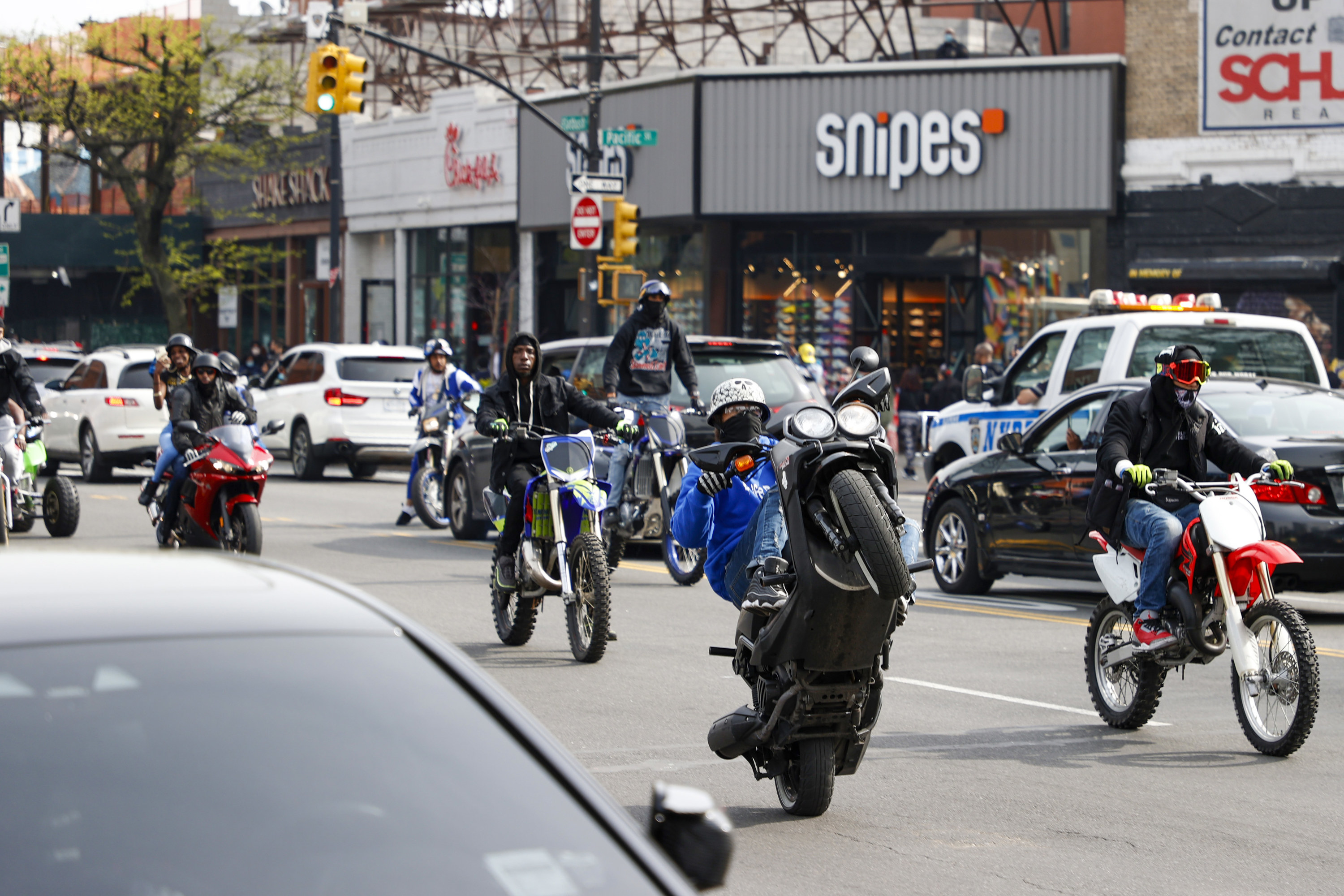 One motorcyclist does a wheelie on the streets of Brooklyn