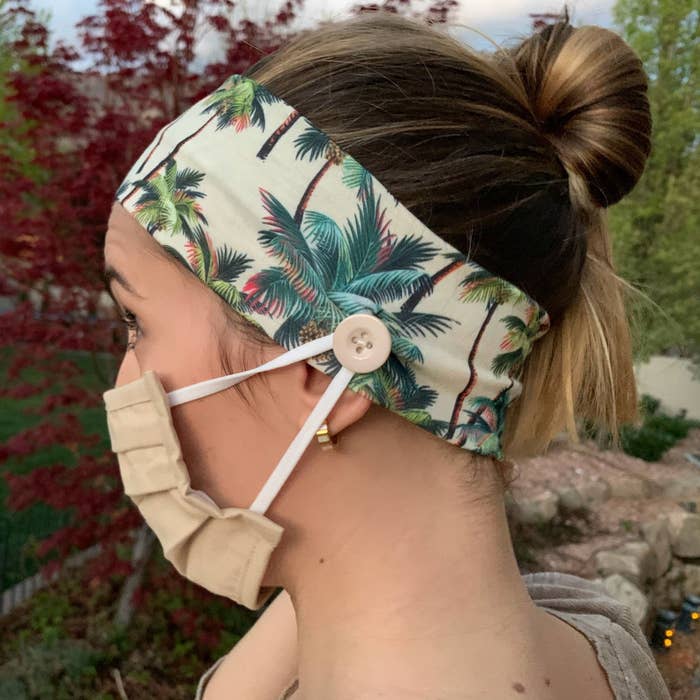 person wearing a face mask with the ear loop attached around a button that's on a headband
