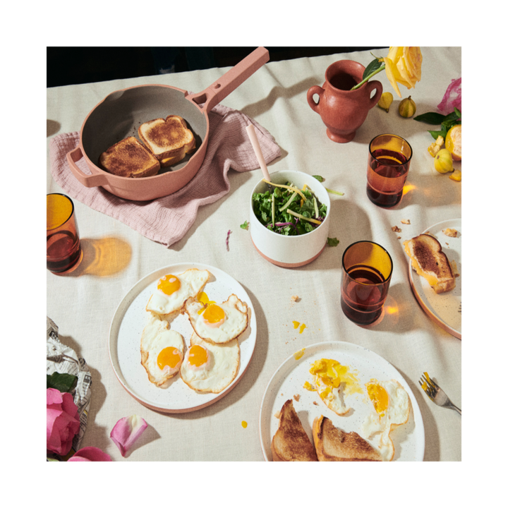 a table full of fried eggs on a plate and other breakfast things