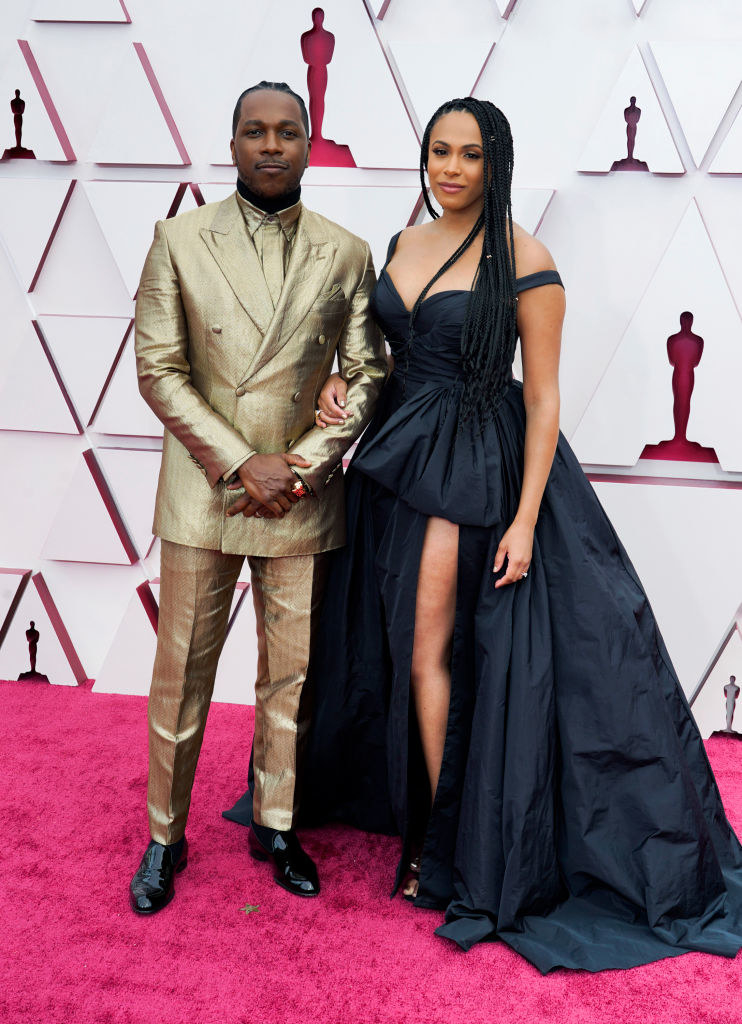 Leslie in a metallic gold suit and his wife in a sweetheart ball gown