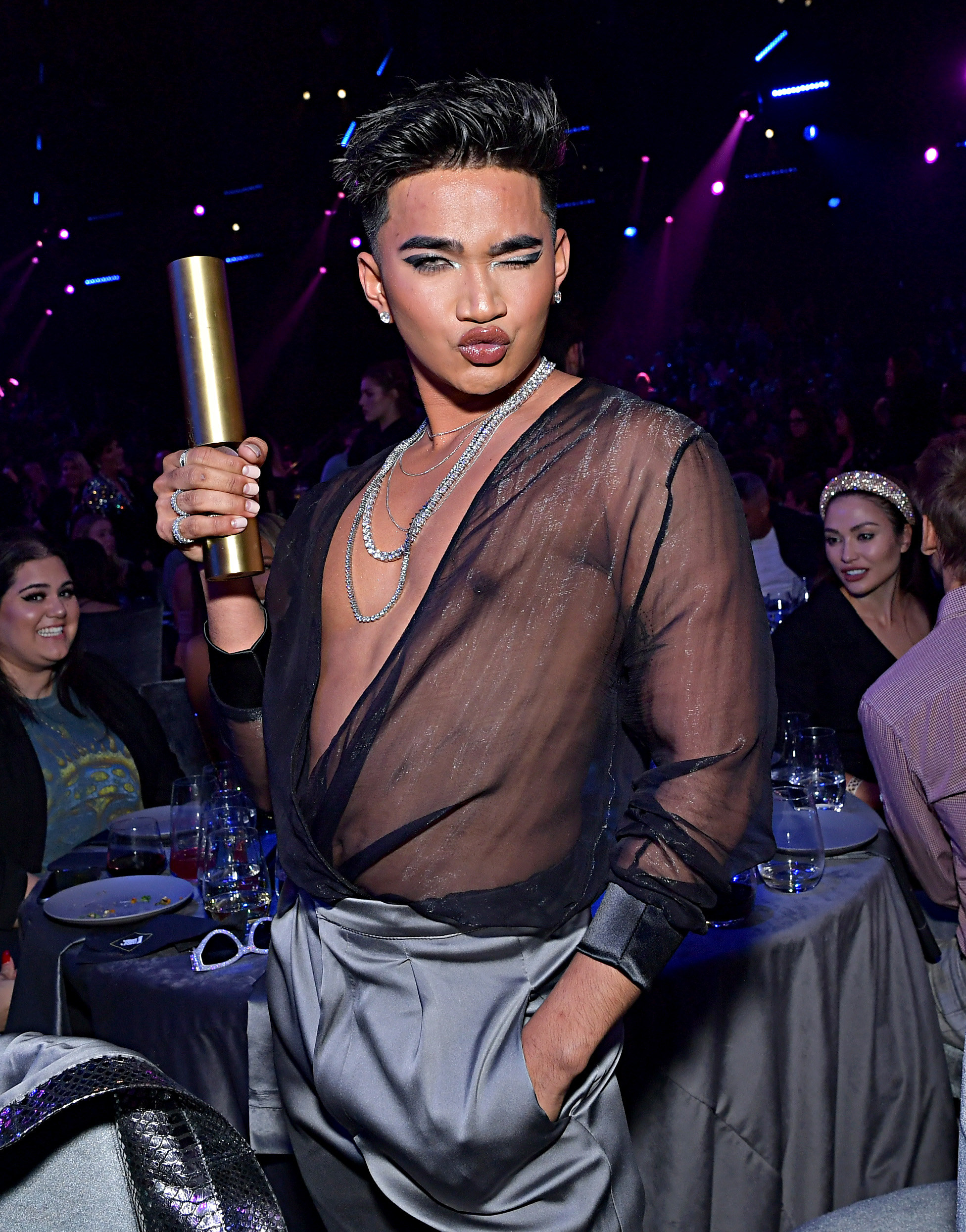 Bretman holding his award and posing for a photo