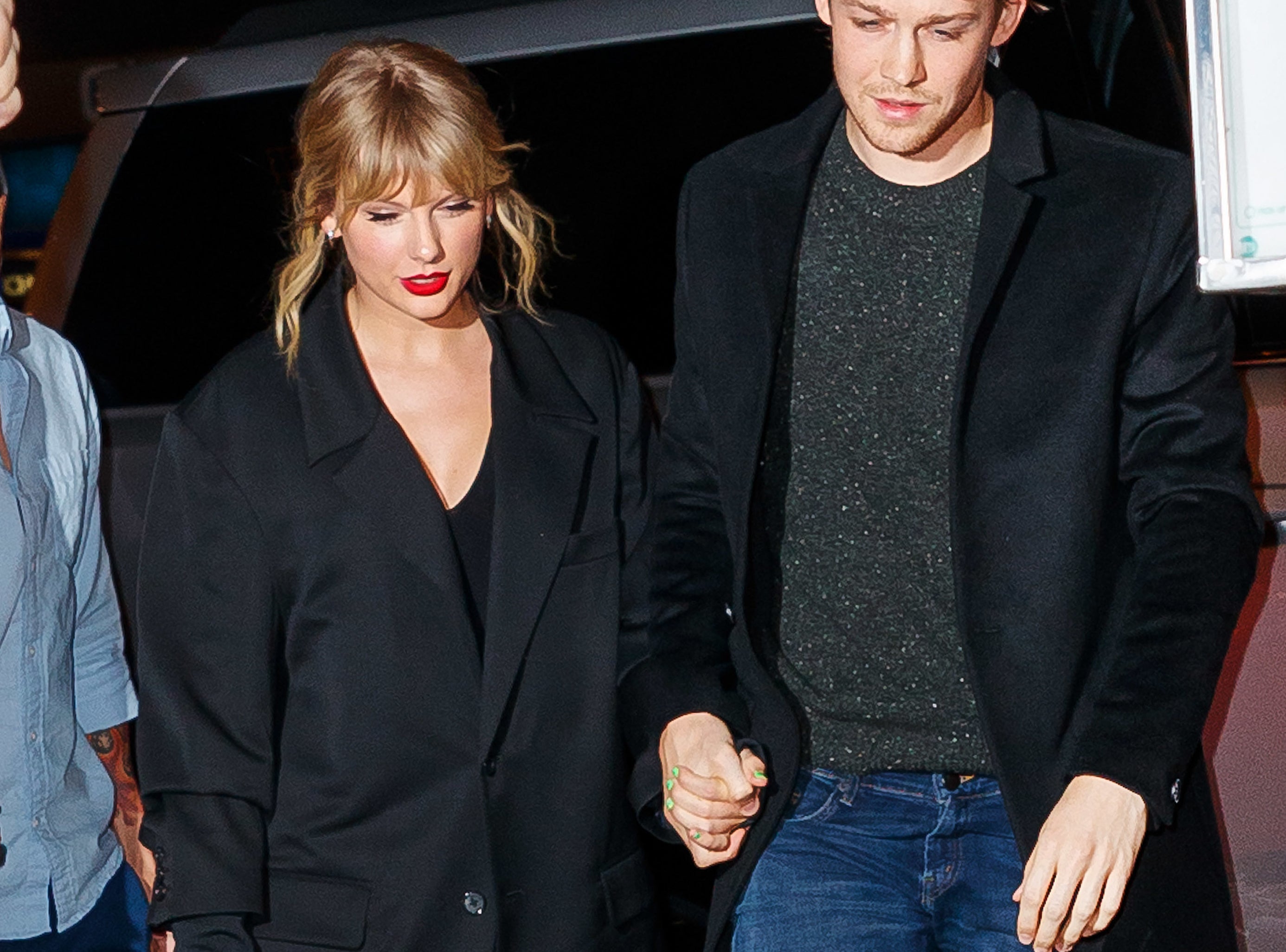 Taylor and Joe hold hands while exiting their car