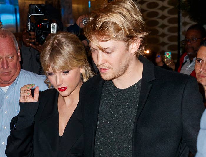 Joe and Taylor hold on to each other while leaving an event