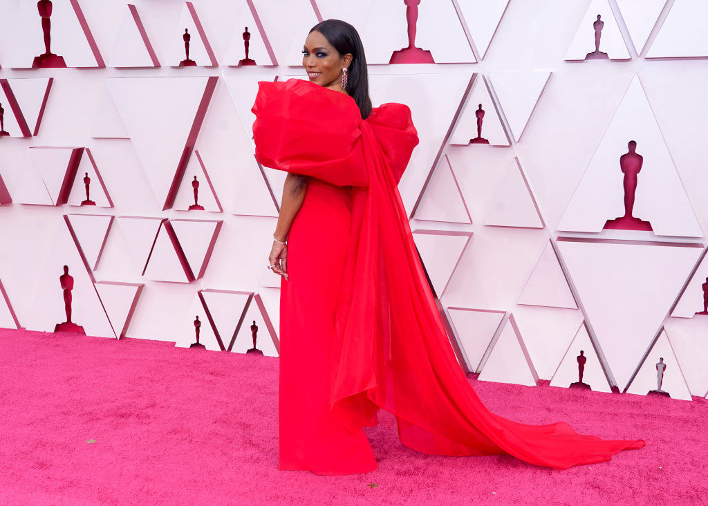 Angela in gown featuring large shoulders and a train