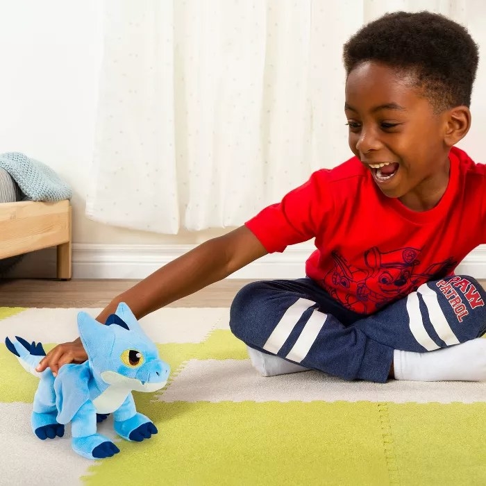 A child playing with the dragon doll