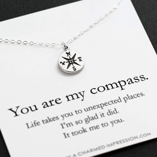 The necklace in its packaging which reads, &quot;You are my compass. Life takes you to unexpected placed. I&#x27;m so glad it did. It took me to you&quot; 