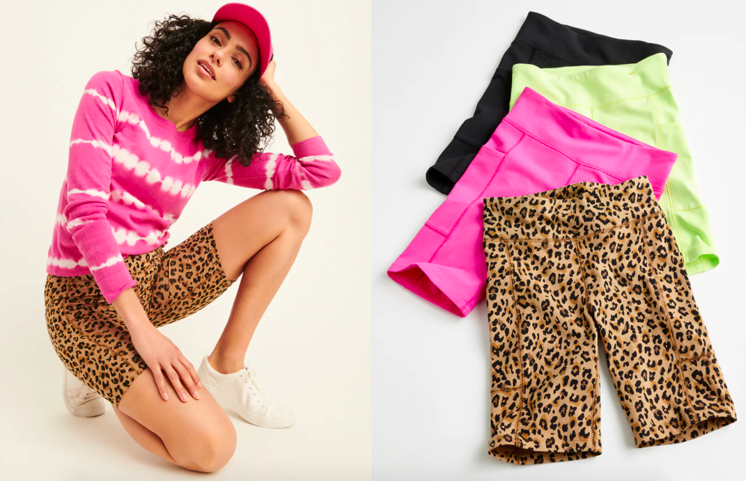 A model wearing the leopard print shorts next to a pile of a variety of the biker shorts