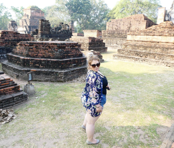 plus size reviewer at a tourist site of ruins wearing shorts