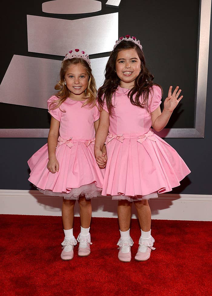 Sophia Grace and Rosie in matching frilly dresses, Mary Jane shoes, and tiaras