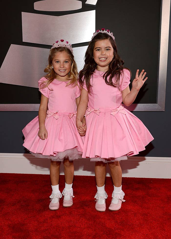 Sophia Grace and Rosie in matching frilly dresses, Mary Jane shoes, and tia...