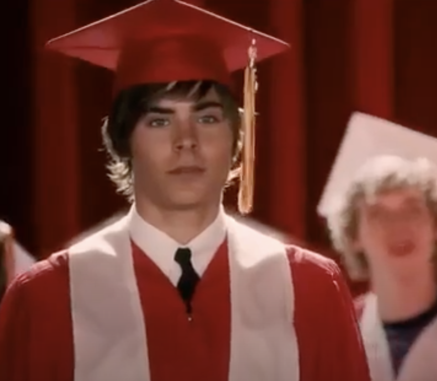 Troy is dressed in a graduation gown looking straight ahead