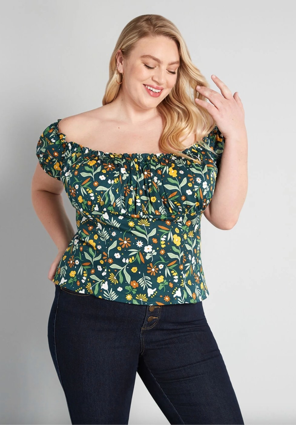 The off the shoulder top in green floral being worn by a model