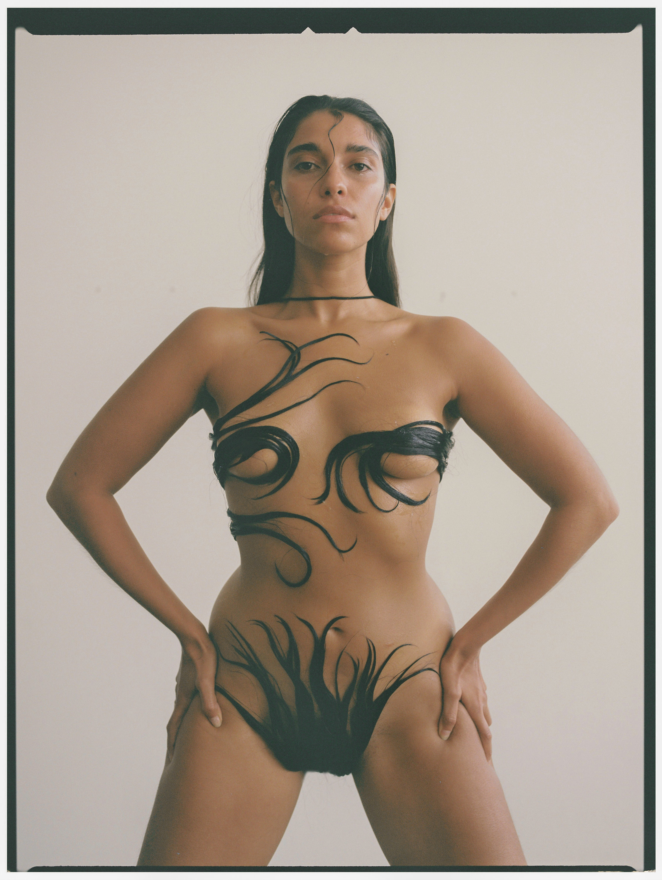 A woman posed naked with her hair covering her breasts 