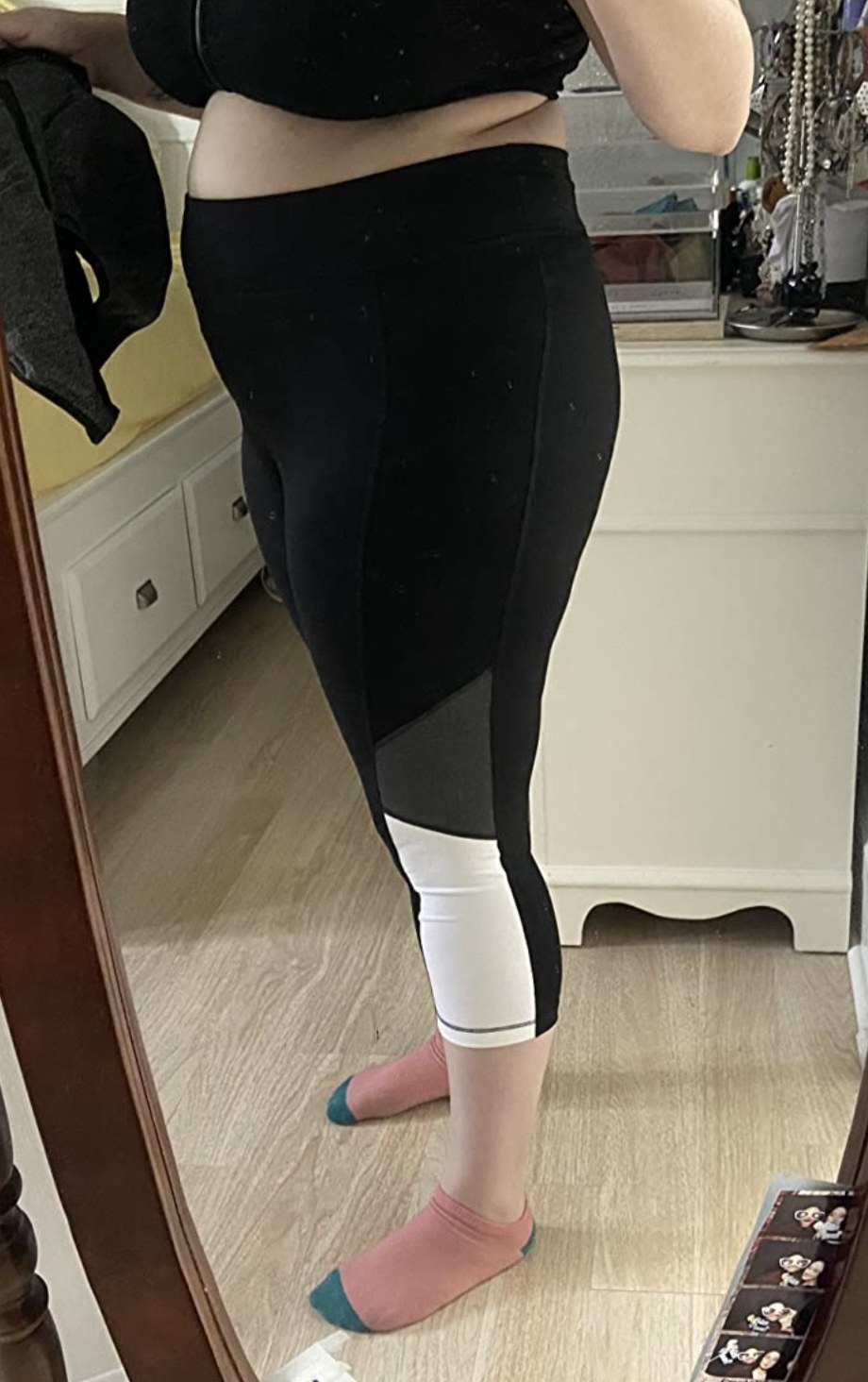 a reviewer wearing tri-colored yoga pants with a capri-length leg