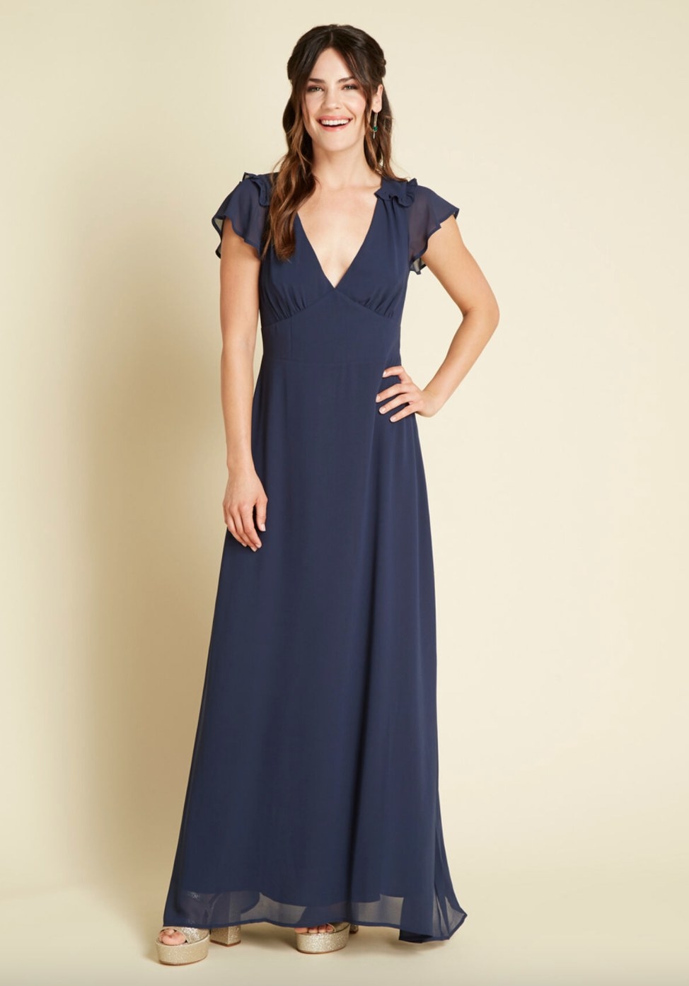 The flow maxi dress in navy being worn by a model in platform heels