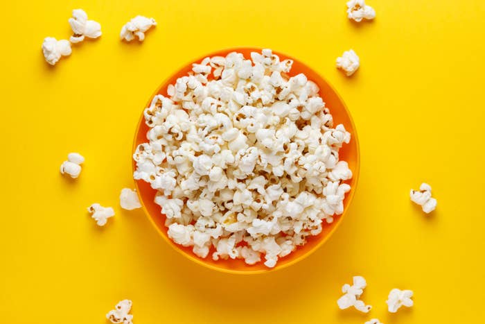 An image of popcorn in a bowl over a yellow background