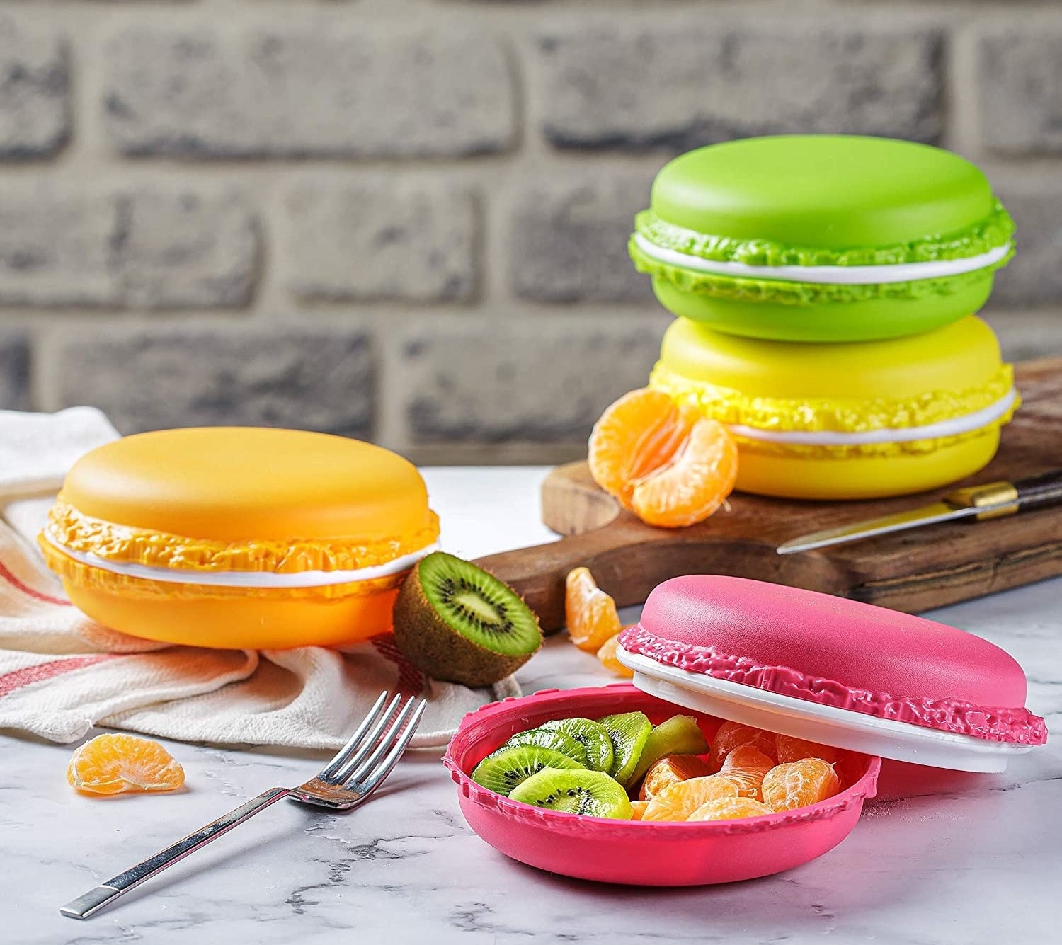 four macaron-shaped containers in orange, yellow, green, and pink