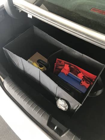 a reviewer photo of the trunk organizer inside of a trunk