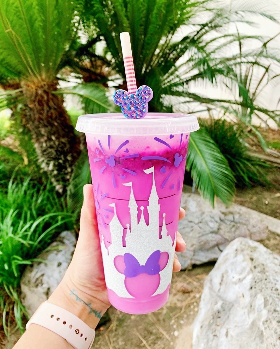 a model holding a disney-inspired tumbler with minnie mouse and the magic castle