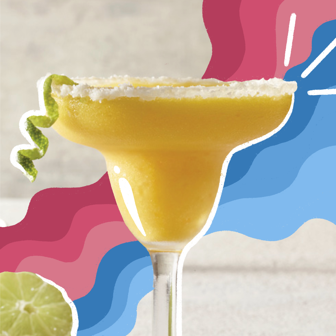 Close-up of frozen mango margarita with curly lime peel garnish.