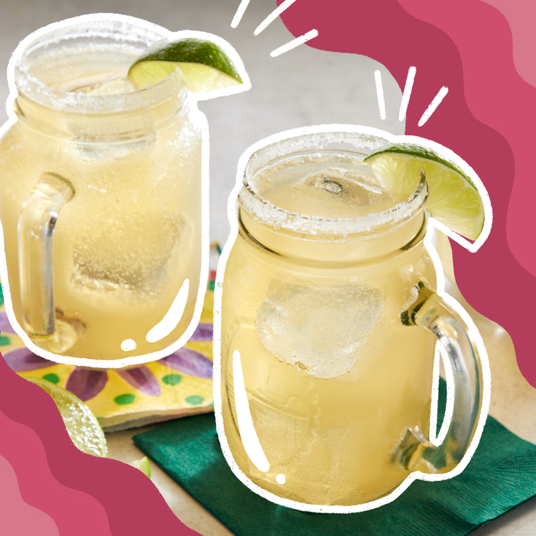 Beer margaritas served in mason jars with lime wedges.