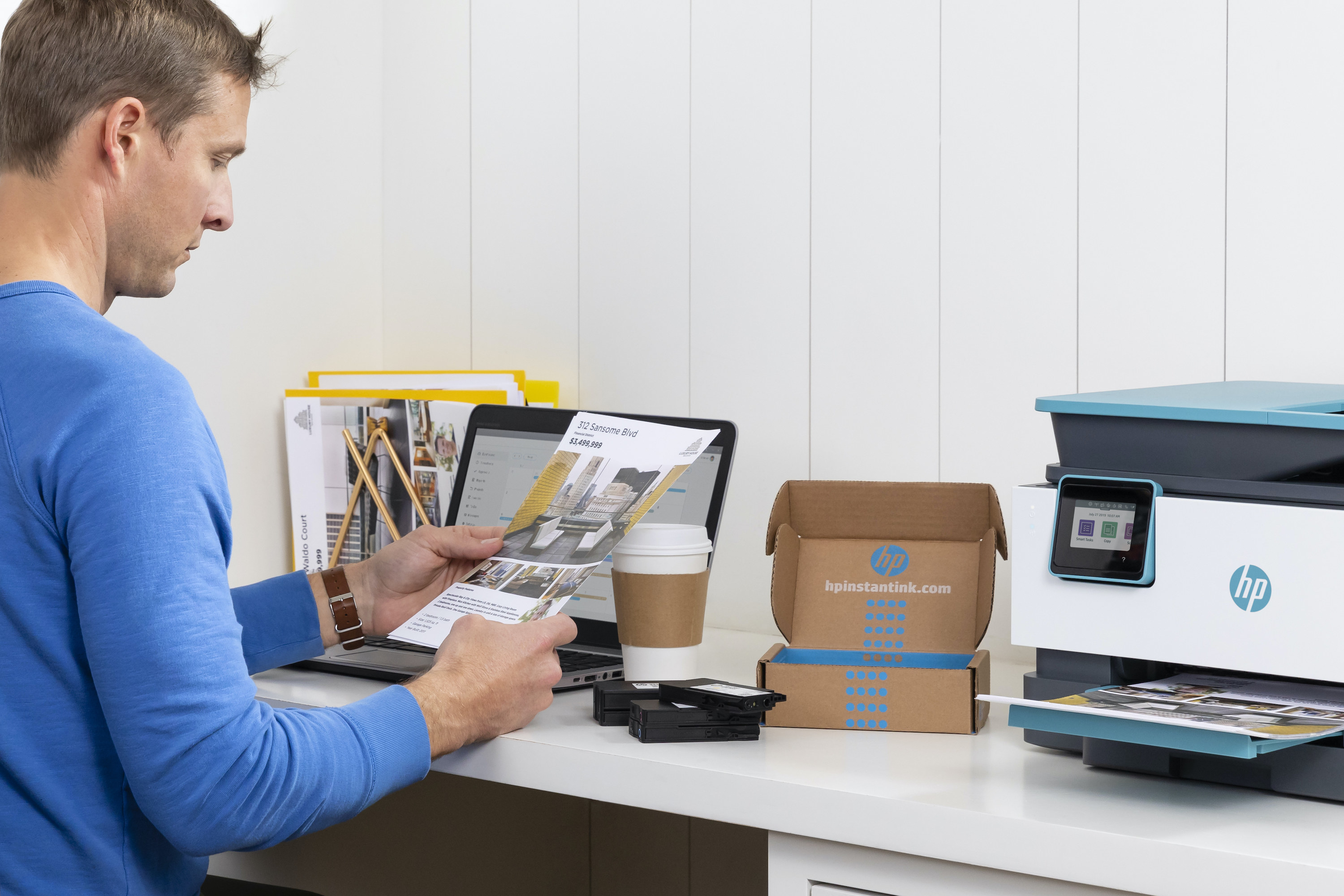 A man reading a document next to an HP printer