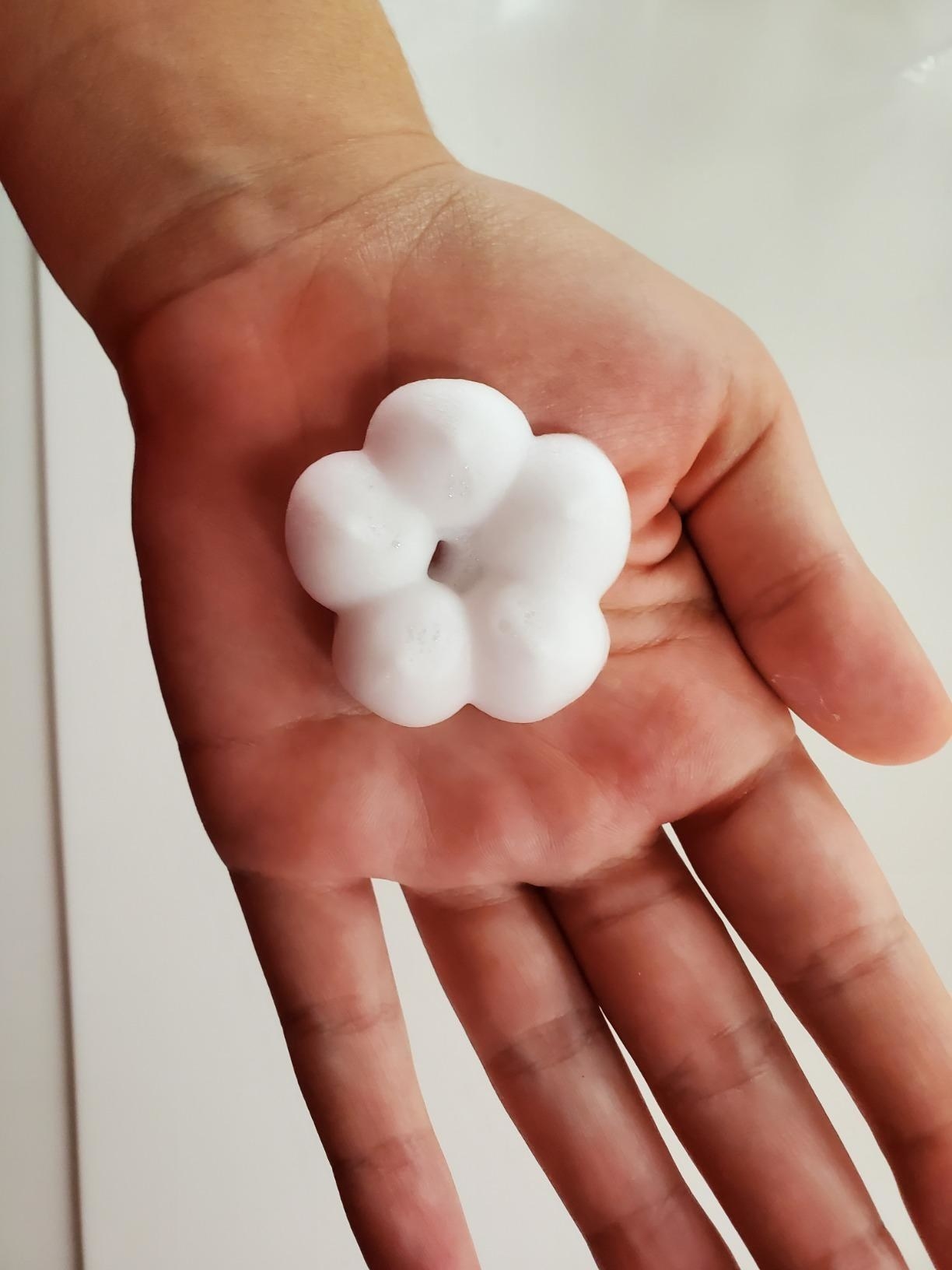 hand holds flower shaped dollop of soap 