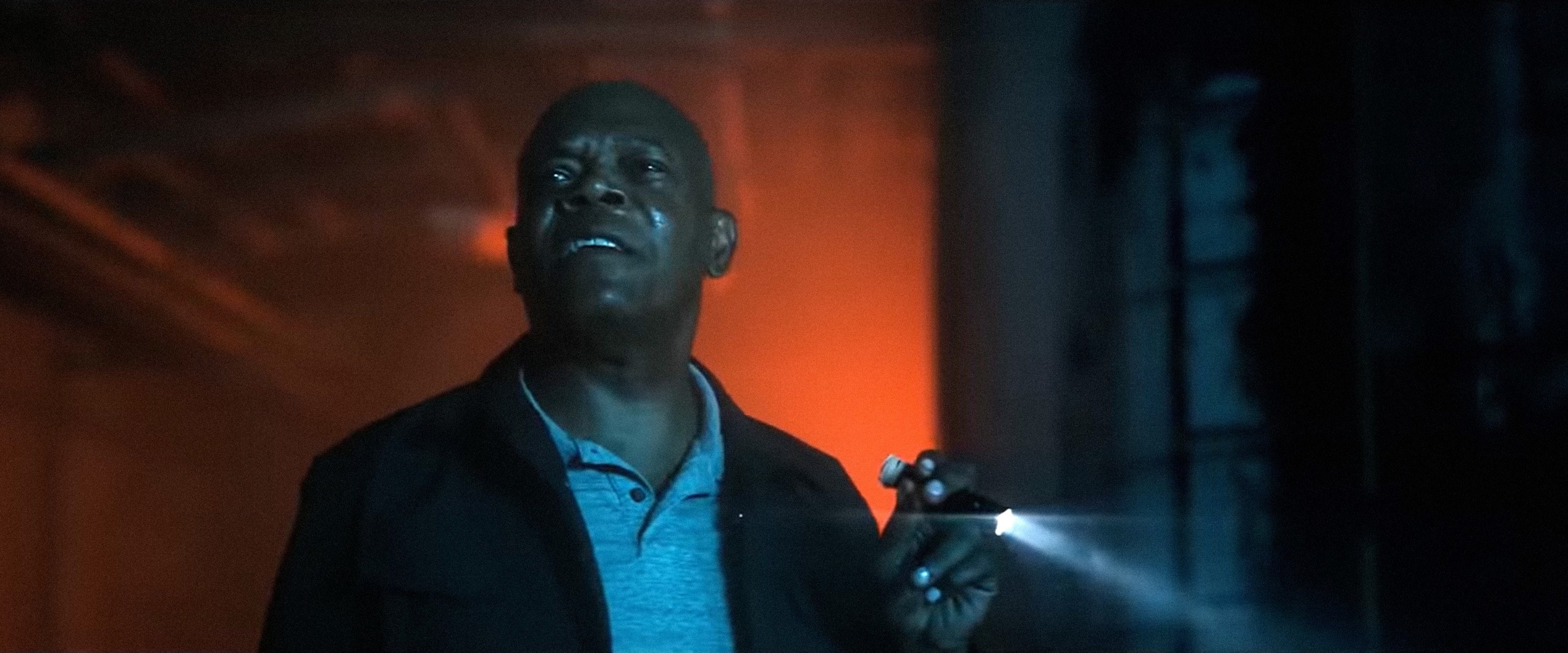 Samuel L. Jackson using a flashlight while looking ahead