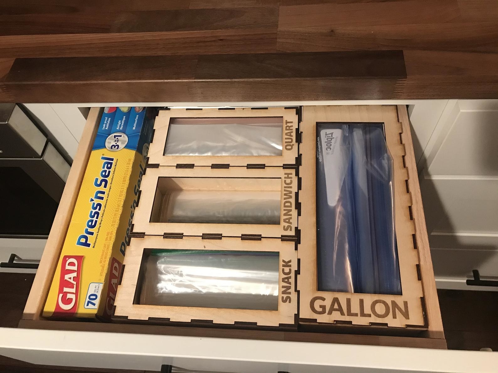 open kitchen drawer with sections for different sized plastic bags