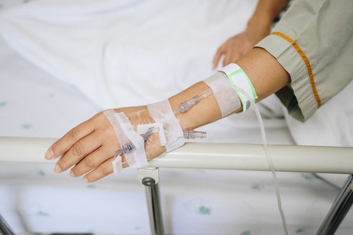 Stock image of a person with an IV in their hand.