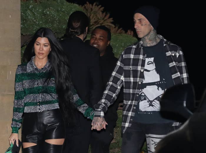 Travis and Kourtney hold hands while leaving a restaurant