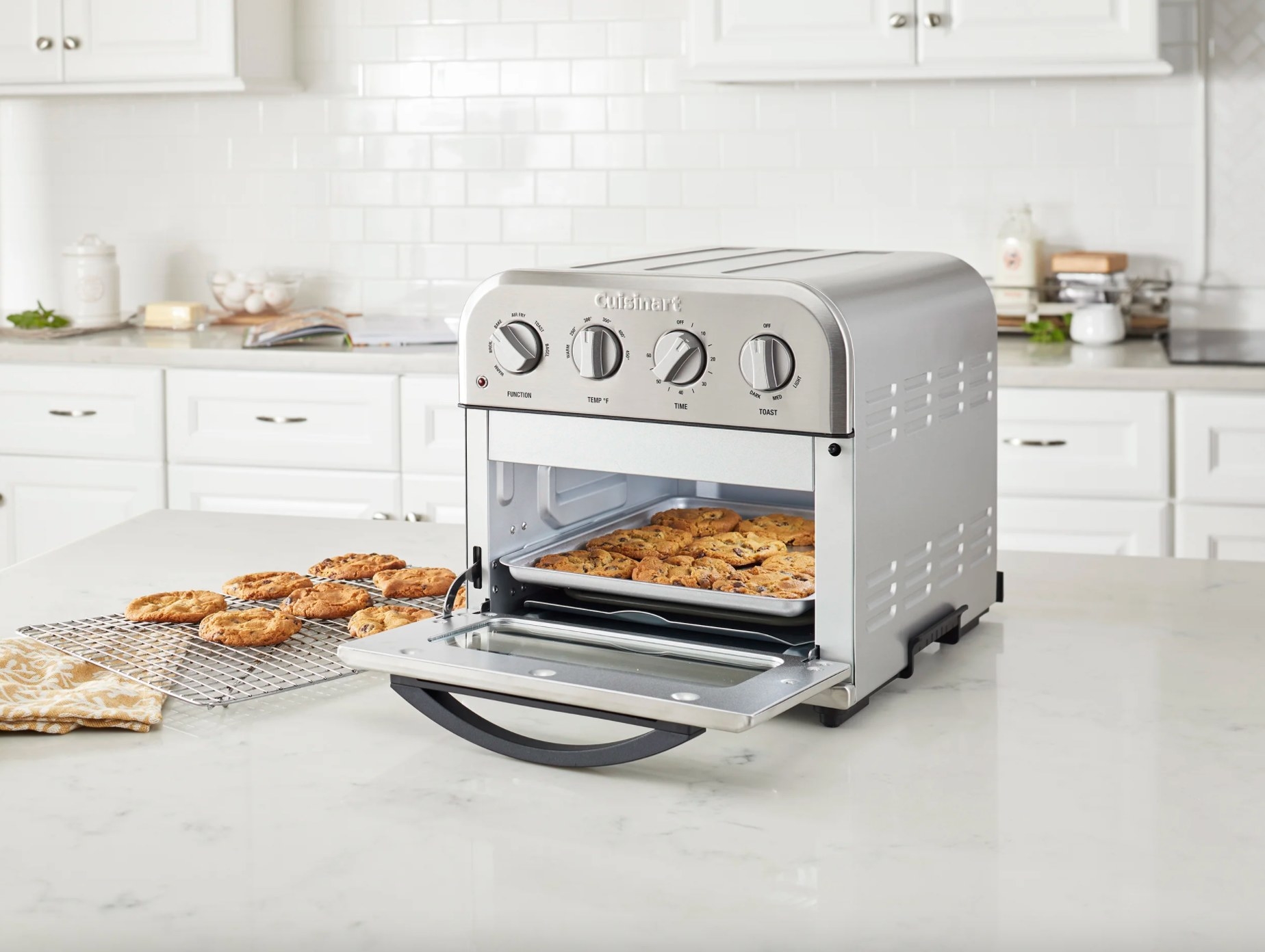 The Cuisinart compact airfryer toaster oven in stainless steel being used to bake cookies