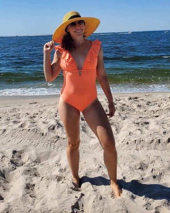 reviewer wearing the plunging keyhole suit with ruffled straps in orange