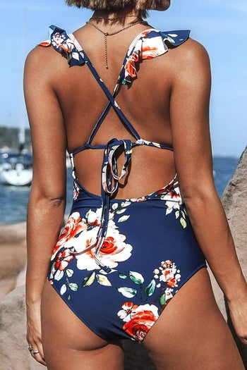 Model wearing navy floral version, shown from behind to show off strappy back
