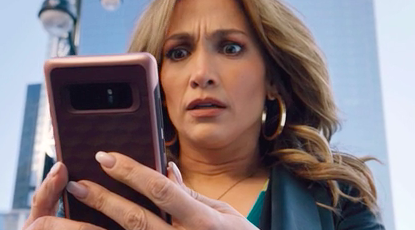 JLO looking at her phone in shock 