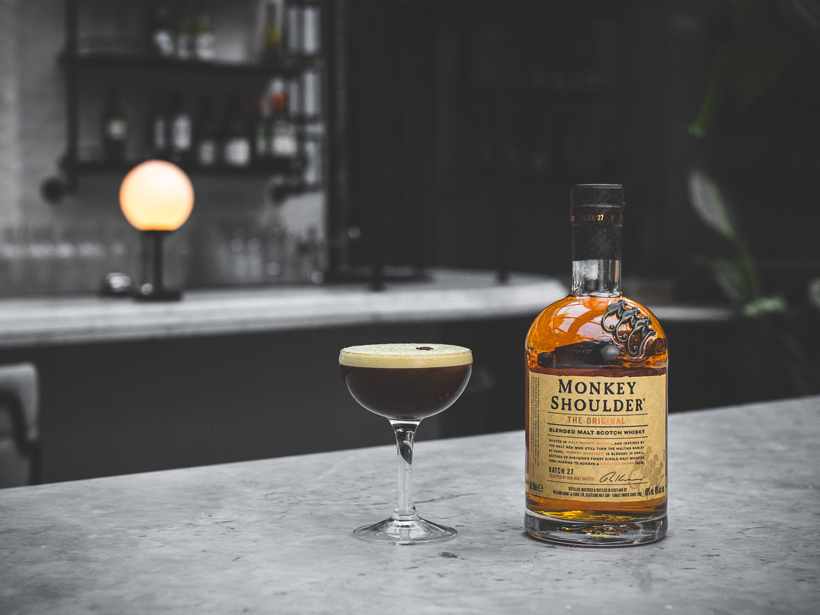 espresso martini cocktail in glass next to a bottle of monkey shoulder whisky