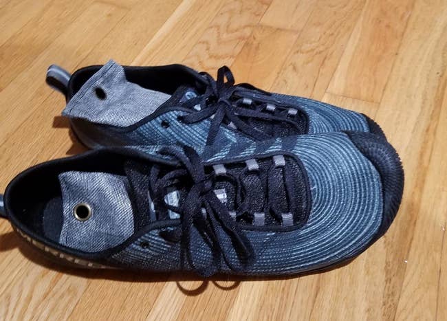 a reviewer photo of a pair of sneakers with dark blue shoe deodorizers inside 