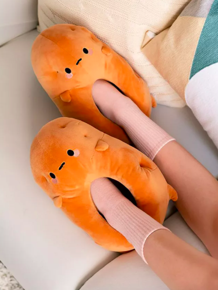 The orange potato-shaped slippers feature a somber, neutral face on the front of them