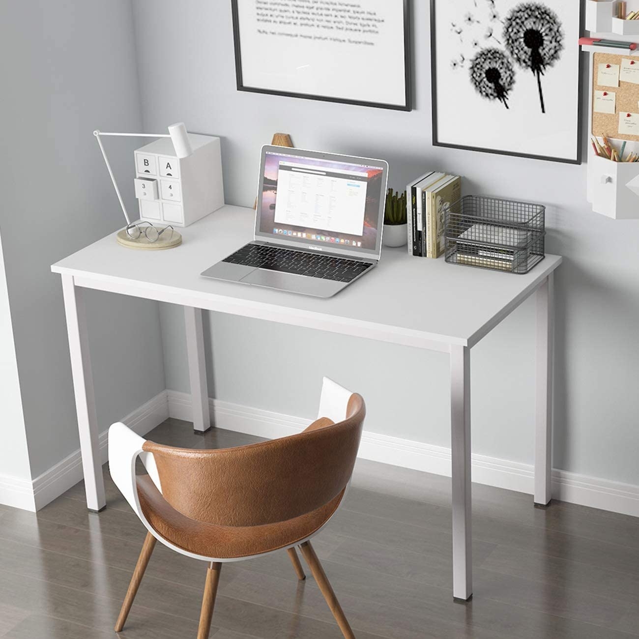 A simple desk with a laptop and organizers on top 