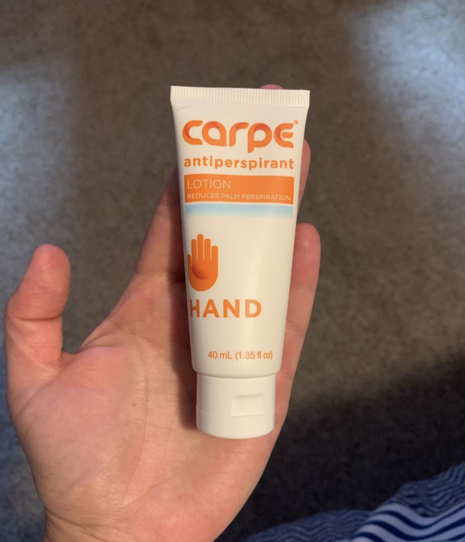 Reviewer with tube of product in their sweat-free palm
