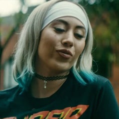 Kali Uchis talking outside in the movie blast beat 